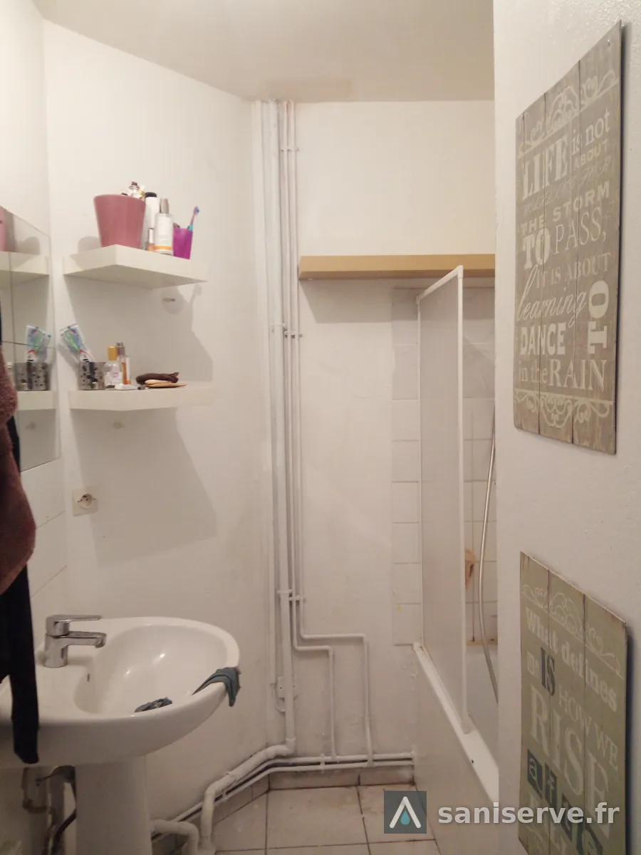 Salle de bain dégagée après le déplacement du cumulus, avec canalisations reprises, à Fresnes-sur-Escaut