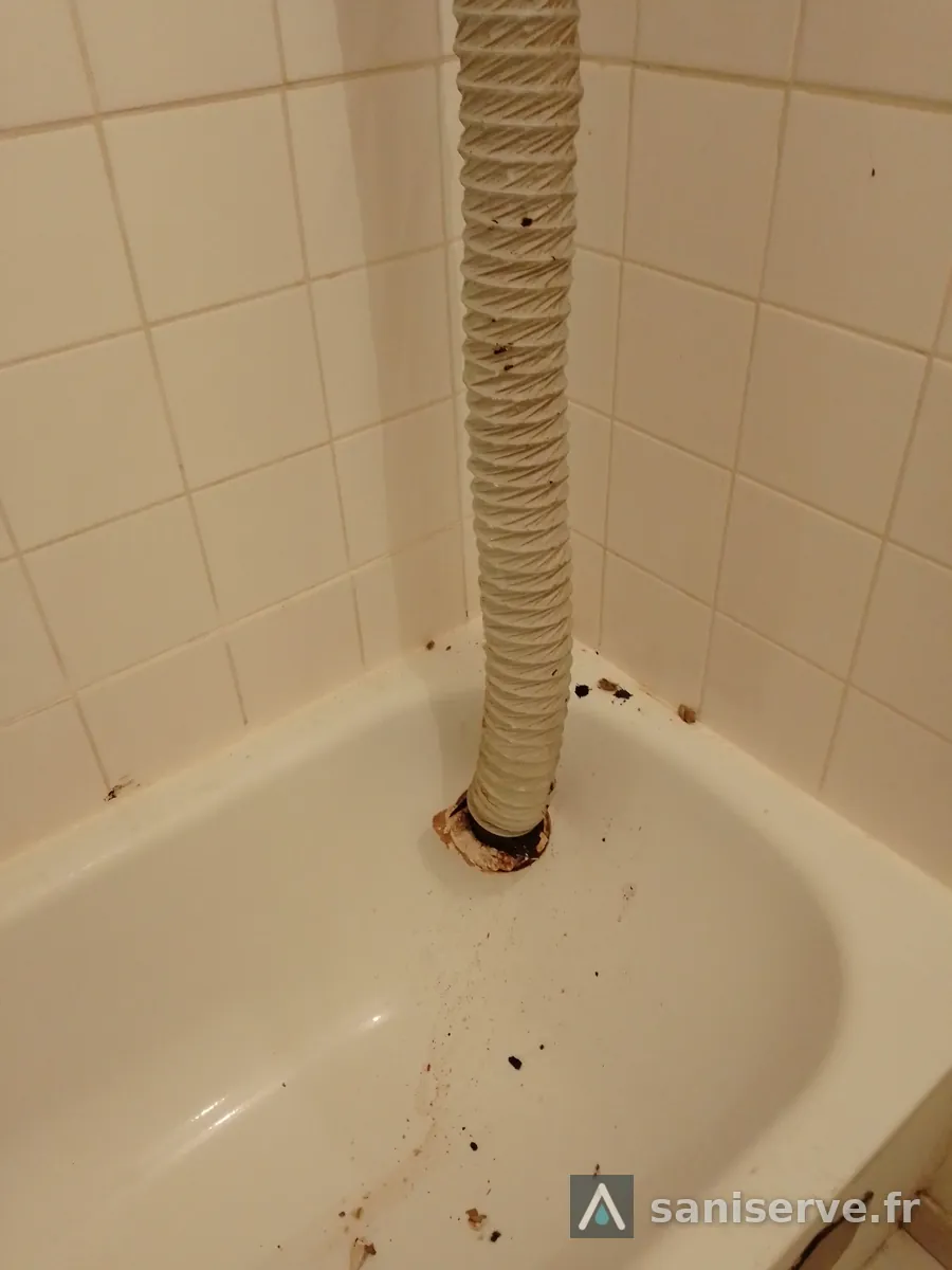 Ancienne gaine de VMC non isolée descendant dans l'angle de la baignoire, avant travaux à Fresnes-sur-Escaut
