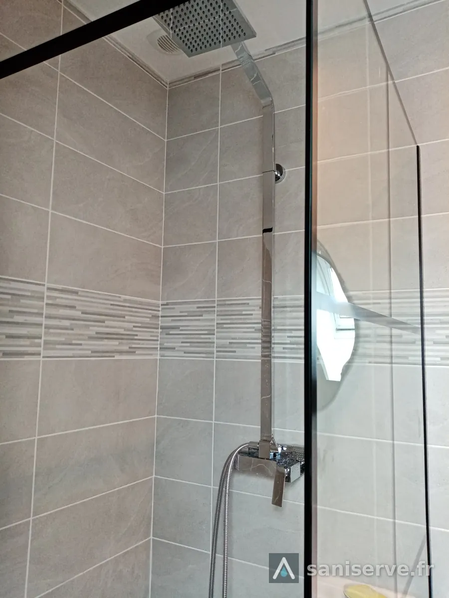 Colonne de douche chromée et faïence avec frise dans la nouvelle douche