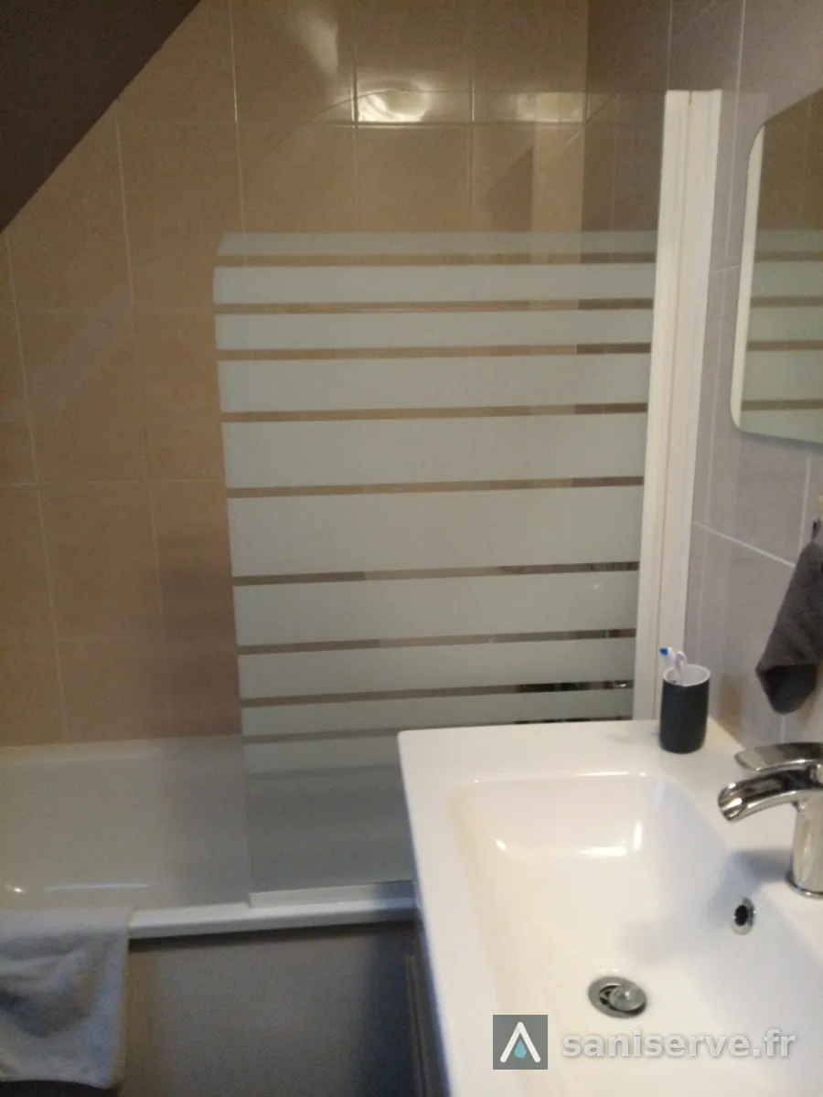 Ancienne baignoire avec pare-bain dans une salle de bain sous pente à Somain, avant travaux