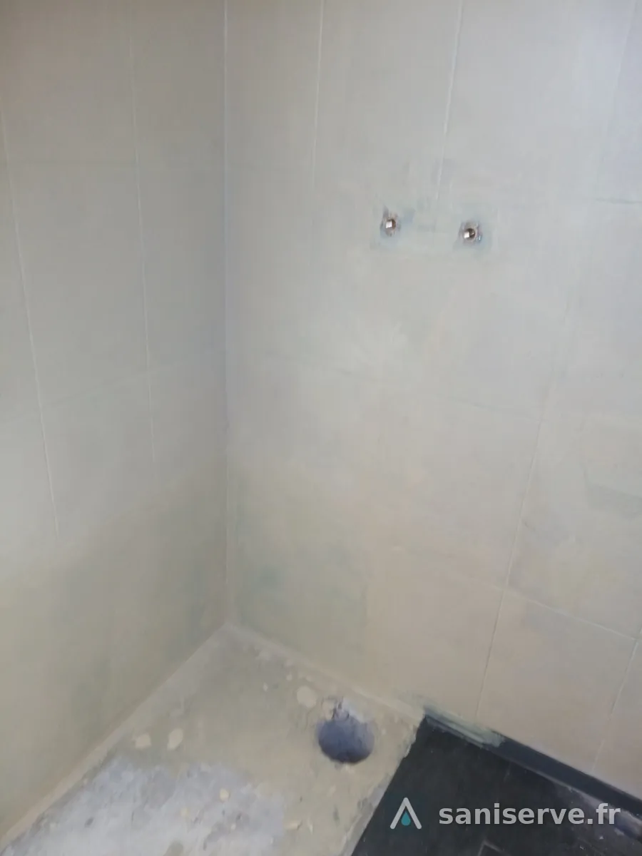 Carottage de la dalle béton armé pour le siphon vertical du receveur de douche