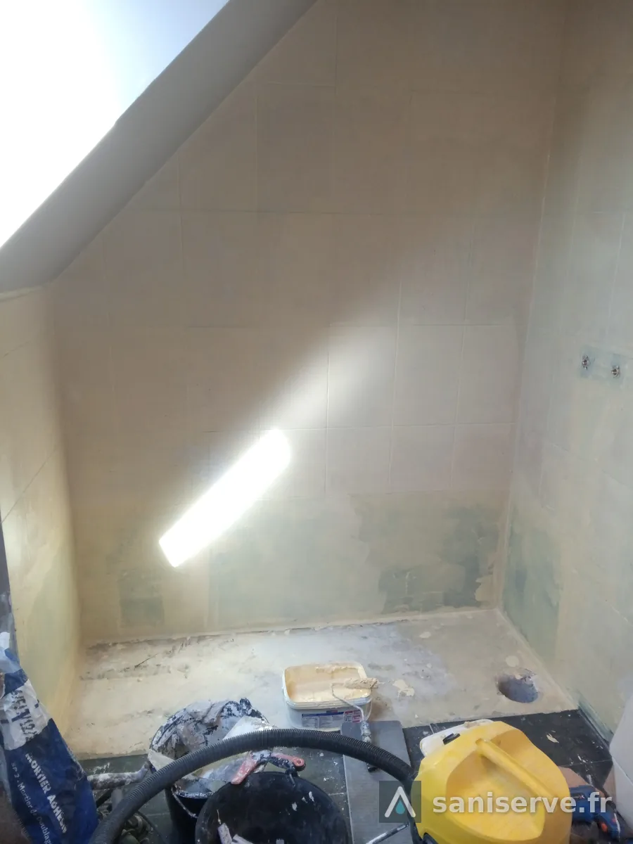 Emplacement de la baignoire après dépose, murs à nu, dans la salle de bain de Somain