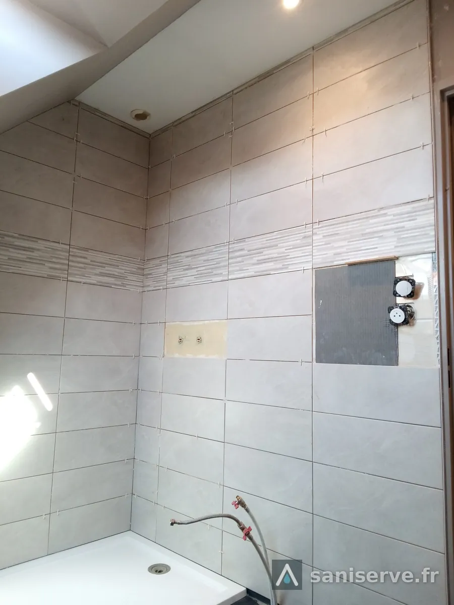 Faïence terminée avec frise et robinetterie de douche encastrée