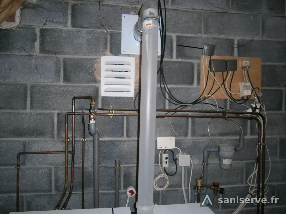 Conduit de fumées vertical et raccordements cuivre au-dessus de la nouvelle chaudière Frisquet à Lecelles