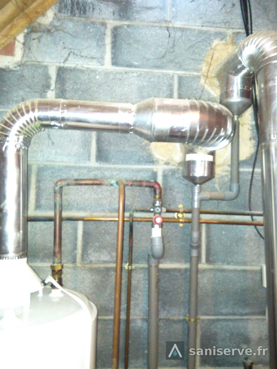 Ancien conduit de fumées flexible en aluminium et tuyauterie cuivre avant remplacement de la chaudière à Lecelles