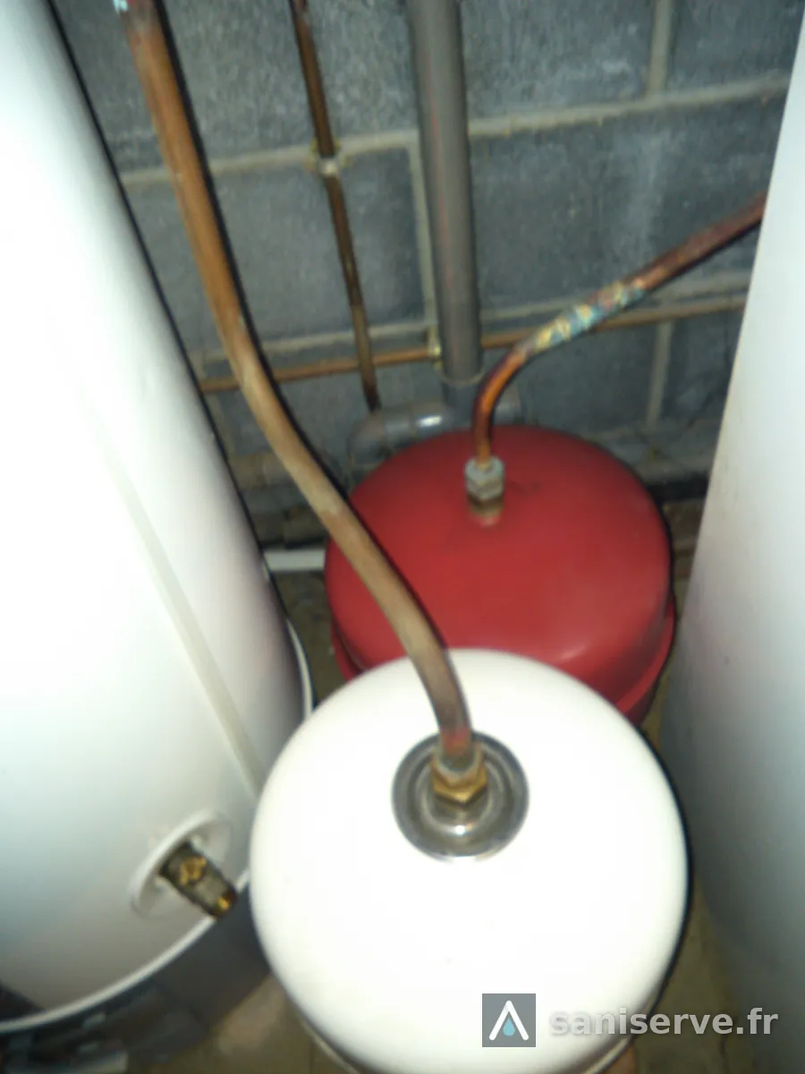 Ancienne installation de chauffage à Lecelles avec vases d'expansion rouge et blanc, avant remplacement